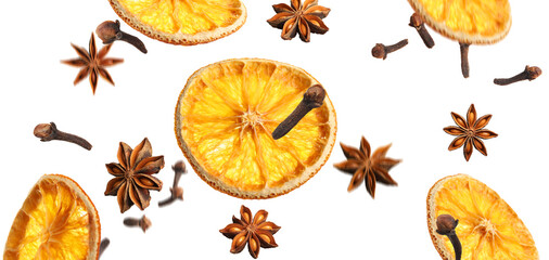 Slices of dried orange, aromatic anise stars and cloves falling on white background. Banner design