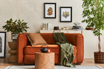 Creative composition of stylish living room interior with mock up poster frames, orange sofa, beige...