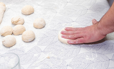 Male hands, a man bakes homemade bread in the home kitchen.