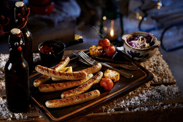 Grilled sausages and vegetables with bottles of beer