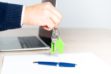 Close up of a man's hand handing over the keys to the new home after signing for the purchase of...