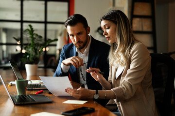 Colleagues in office. Businesswoman and businessman discussing work in office. Two friends working together.