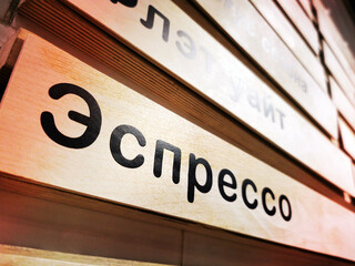 The inscription Espresso in Russian language on the wall of the coffee shop