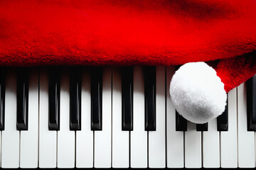Christmas music. Santa Claus hat and piano keys, keyboard. Playful red white black Xmas background.