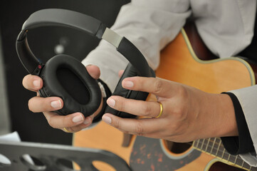 guitarist hand holding earphones(selective focus), guitar music  practice equipment concept