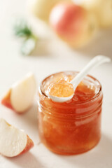 Apple jam in a glass jar. Apple jam on a light background. Delicious natural marmalade.