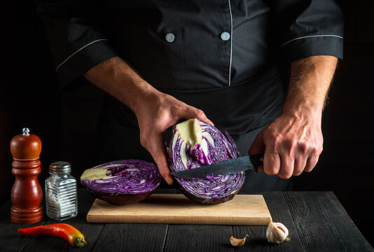 Cook cutting red cabbage with a knife. Cooking vegetable salad in the restaurant kitchen. Vegetable diet idea - Powered by Adobe