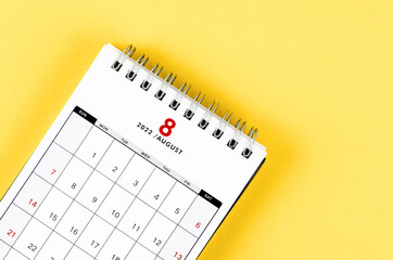 August 2022 desk calendar on yellow background.