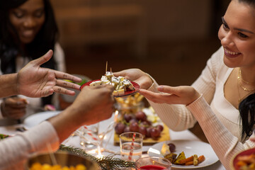 holidays, eating and celebration concept - close up of friends having christmas dinner at home and...
