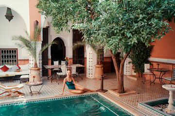 Retreat and vacation. Beautiful young woman relaxing in spa private swimming pool in beautiful...