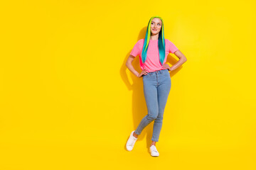 Fototapeta na wymiar Photo of dreamy adorable young vibrant woman wear pink t-shirt looking empty space arms waist isolated yellow color background