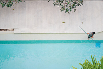 Top view of man cleaning swimming pool.