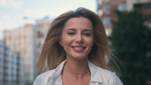 The beautiful smiling woman walking on the street. slow motion