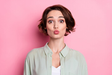Portrait of attractive cheerful funny brown-haired girl sending air kiss amour isolated over pastel...