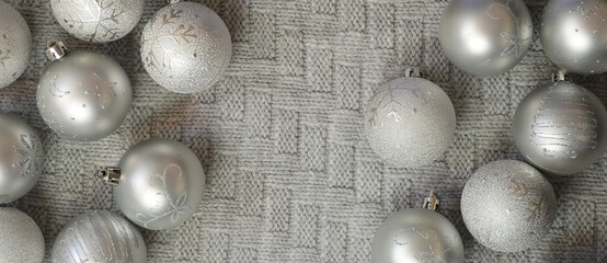 gray shiny Christmas balls on a knitted plaid. background for Christmas and New Year. winter holidays.
