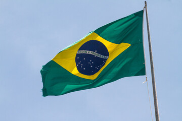 Brazil flag outdoors with beautiful blue sky in the background in Rio de Janeiro.