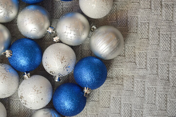 gray and blue shiny Christmas balls on a knitted plaid. background for Christmas and New Year. winter holidays.