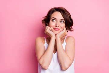 Portrait of attractive cheery feminine girl creating solution isolated over pastel pink color background