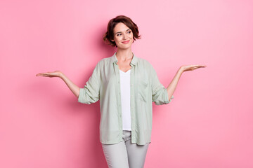 Photo of nice brunette young lady hold empty space wear grey green outfit isolated on pink color background