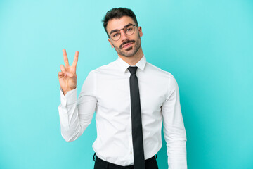 Business caucasian man isolated on blue background smiling and showing victory sign