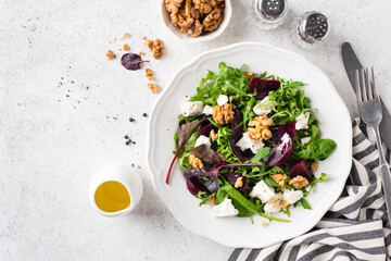 Healthy Beet Salad With Walnuts And Goat Cheese On Plate Garnished With Olive Oil Salad Dressing, Top View Copy Space