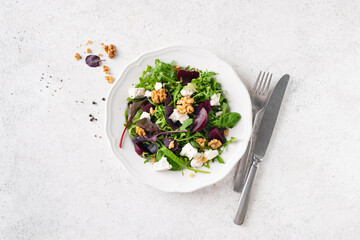 Beetroot salad with soft white feta cheese on a grey cement backdrop, table top view. Copy space...