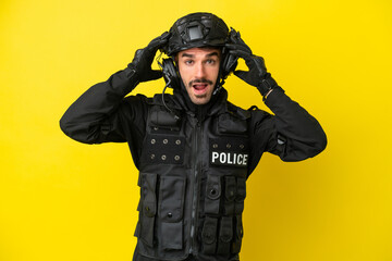 Fototapeta premium SWAT caucasian man isolated on yellow background with surprise expression