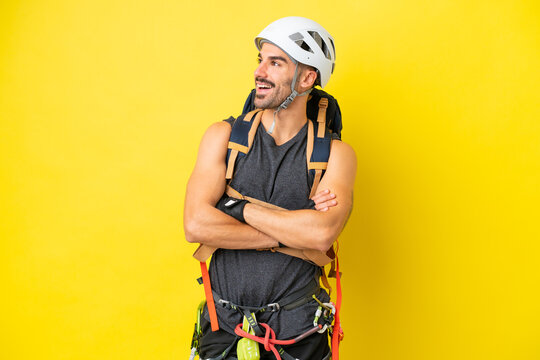 Young caucasian rock climber man isolated on yellow background happy and smiling