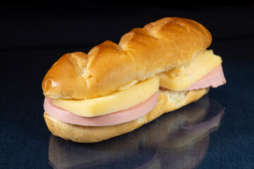 Sandwich with sausage and cheese on the table with a reflection