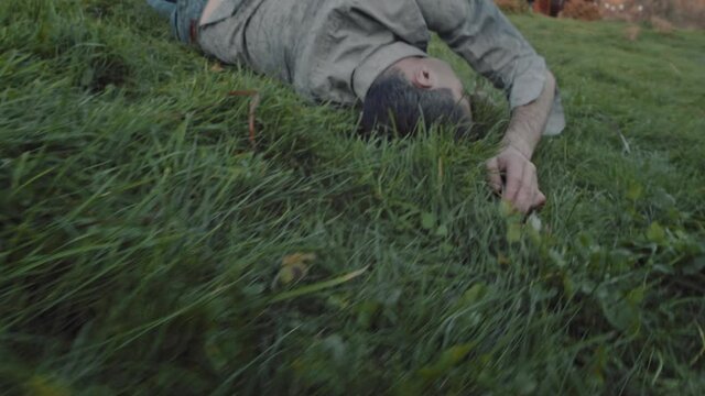 Close up of a middle aged man dancing contemporary improvisation dance on a meadow at dawn. Contemporary dancer dancing at dawn. The concept of freedom and unity with nature