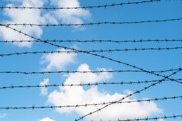 Rows of a barbed wires against blue sky. Concept picture about freedom