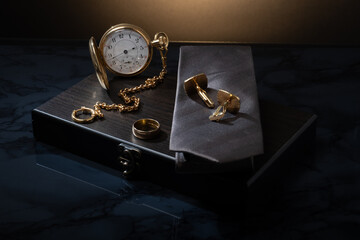 Closeup of a vintage watch and some men's jewelry against studio background. Men's business accessory.