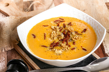 bol de soupe de courge butternut avec noix et lamelles de  chorizo poellées