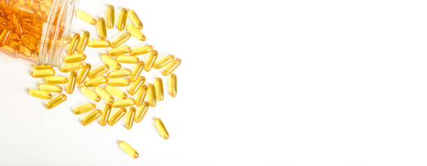Fish oil in gelatin capsules isolate. Omega vitamins in golden colored pills on a blank white banner background. Medicine, pharmacy, drugs and multivitamins oils concept