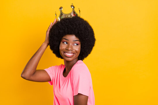 Photo of pretty young lady look empty space wear crown pink t-shirt isolated on yellow color background
