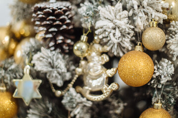 Close-up of the Christmas tree background with toys. Christmas bell, fir cones on the branches of a tree. Christmas decor. The concept of a winter holiday. Happy New Year.