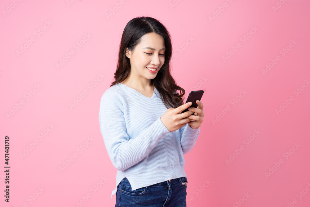 Wall mural Portrait of a beautiful young Asian girl, isolated on pink background