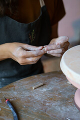 Female hands shaping details for pottery decor during art classes for leisure or education. Woman work with raw clay for entertainment or small business and handcraft potter production retail store