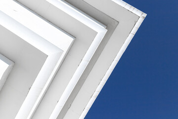 White concrete ceiling corners under clear blue sky
