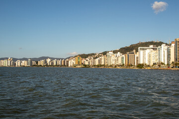 sea water, blue sky and beautiful view of the city's waterfront buildings