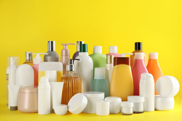 Many different cosmetic products on yellow background