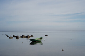 An empty rowing boat marooned in calm shallow waters of Baltic sea