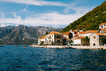 Fototapeta na wymiar Houses with red tiled roofs on the banks of Perast. Montenegro