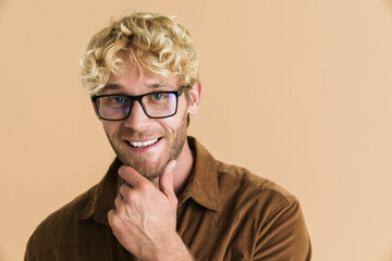 White blonde man in eyeglasses looking and smiling at camera