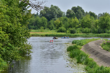 Canoes and boats flowing on the river on a sunny summer day during the holidays.