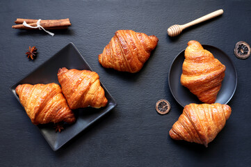 top view photo of homemade baked butter French croissans are on the wooden black table with cinnamon sticks as breakfast in the morning in the cafe during Christmas party with family 