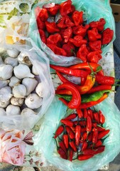 Different varieties of red peppers and garlic are sold in the market