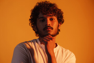 Young bearded man dressed in t-shirt posing and looking at camera