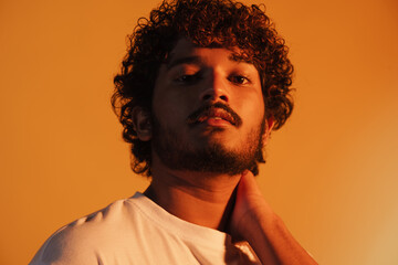 Young bearded man dressed in t-shirt posing and looking at camera