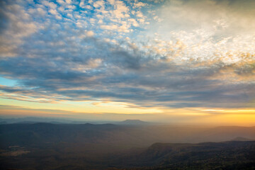 Fototapeta na wymiar Glowing sunrise shines over mountain range.